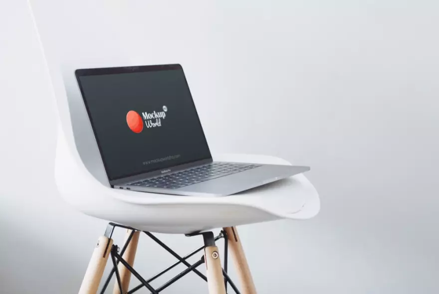 Download Macbook Pro on a chair in front of a white background PSD mockup